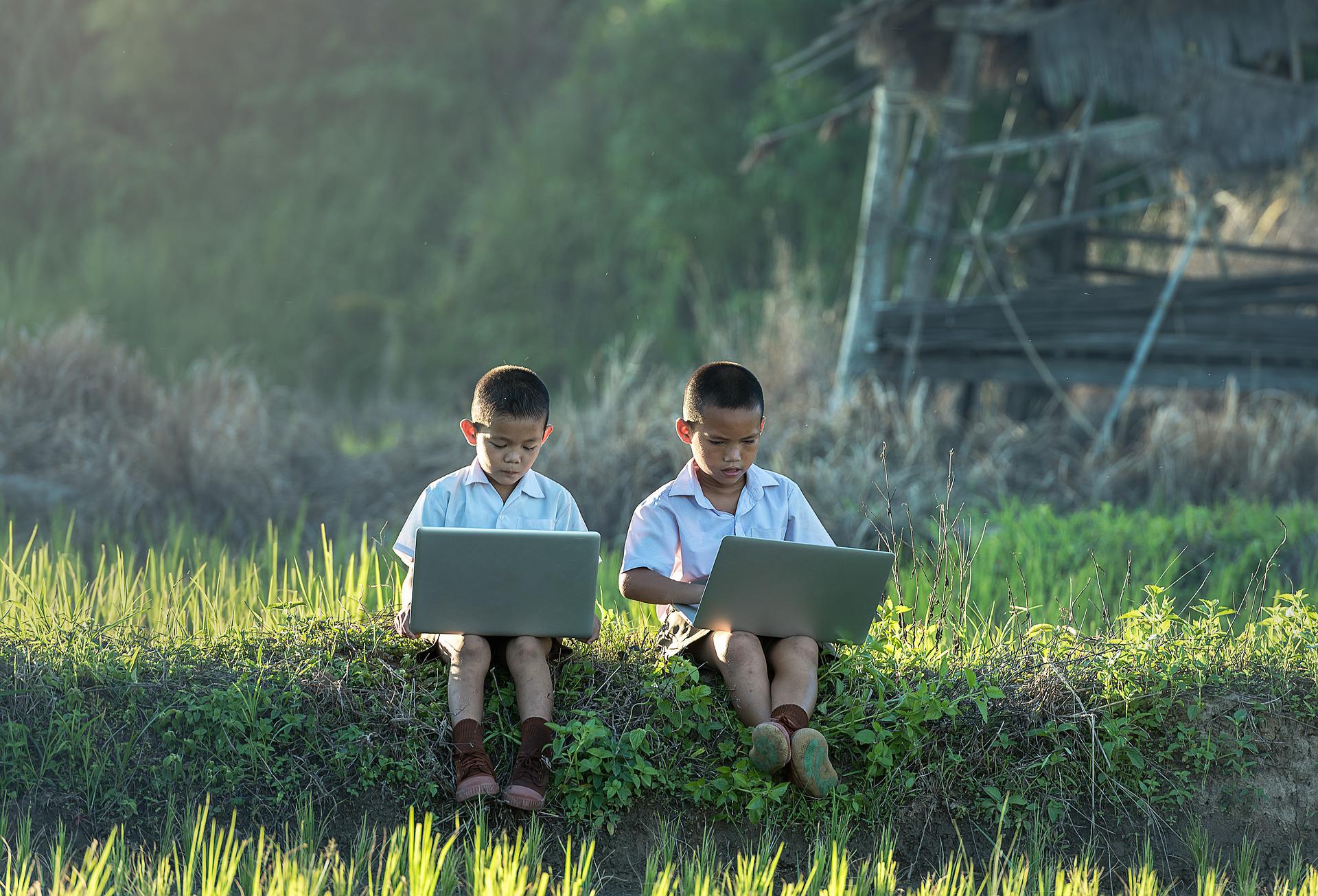 two children playing on gaming laptops